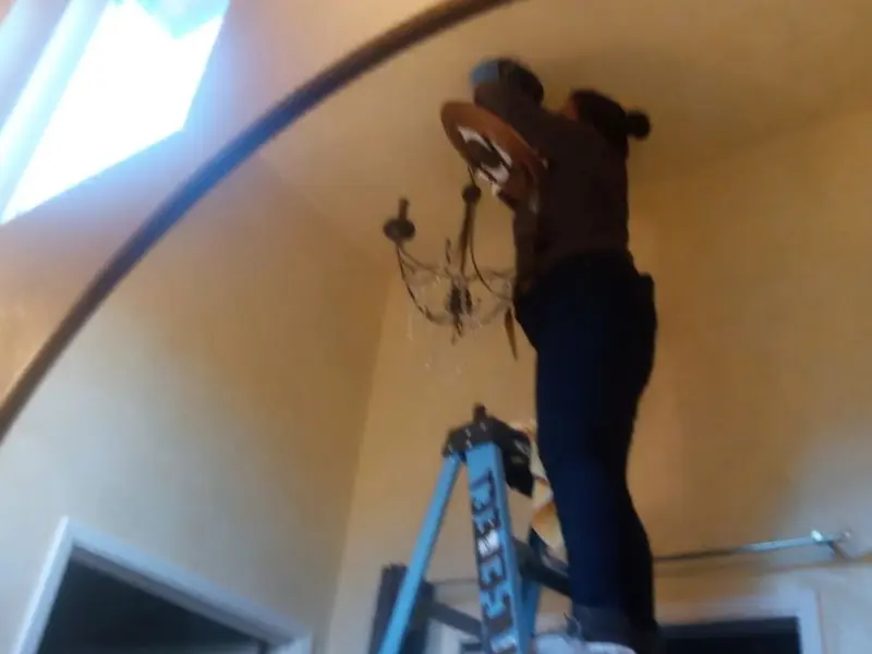 Electrician installing a chandelier in a Hazlehurst residence